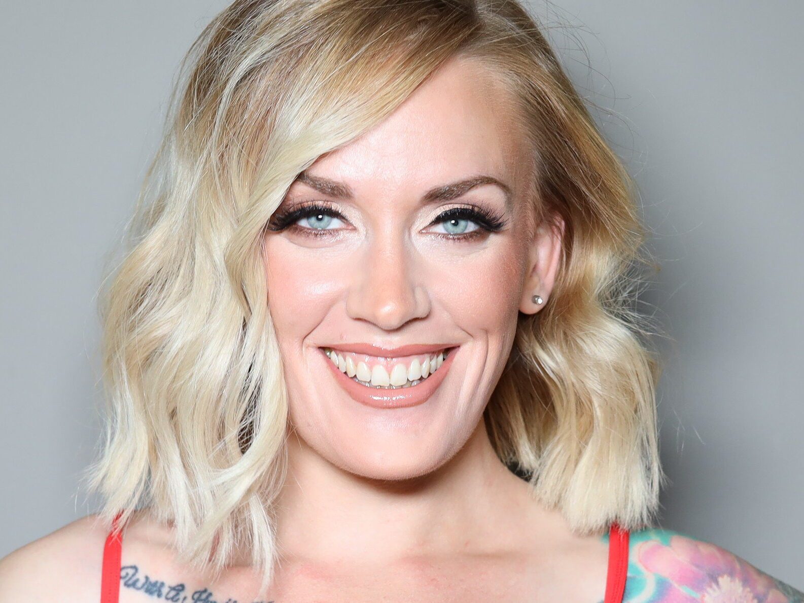Deidra Skappak smiling in front of a soft grey backdrop