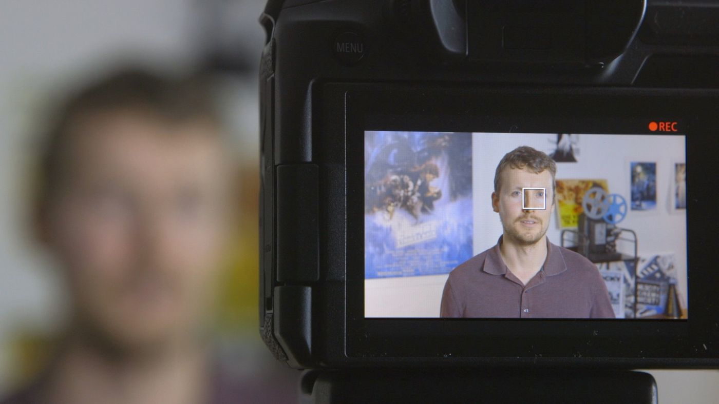 Zachary Tannar seen on a camera's monitor, framed for an interview