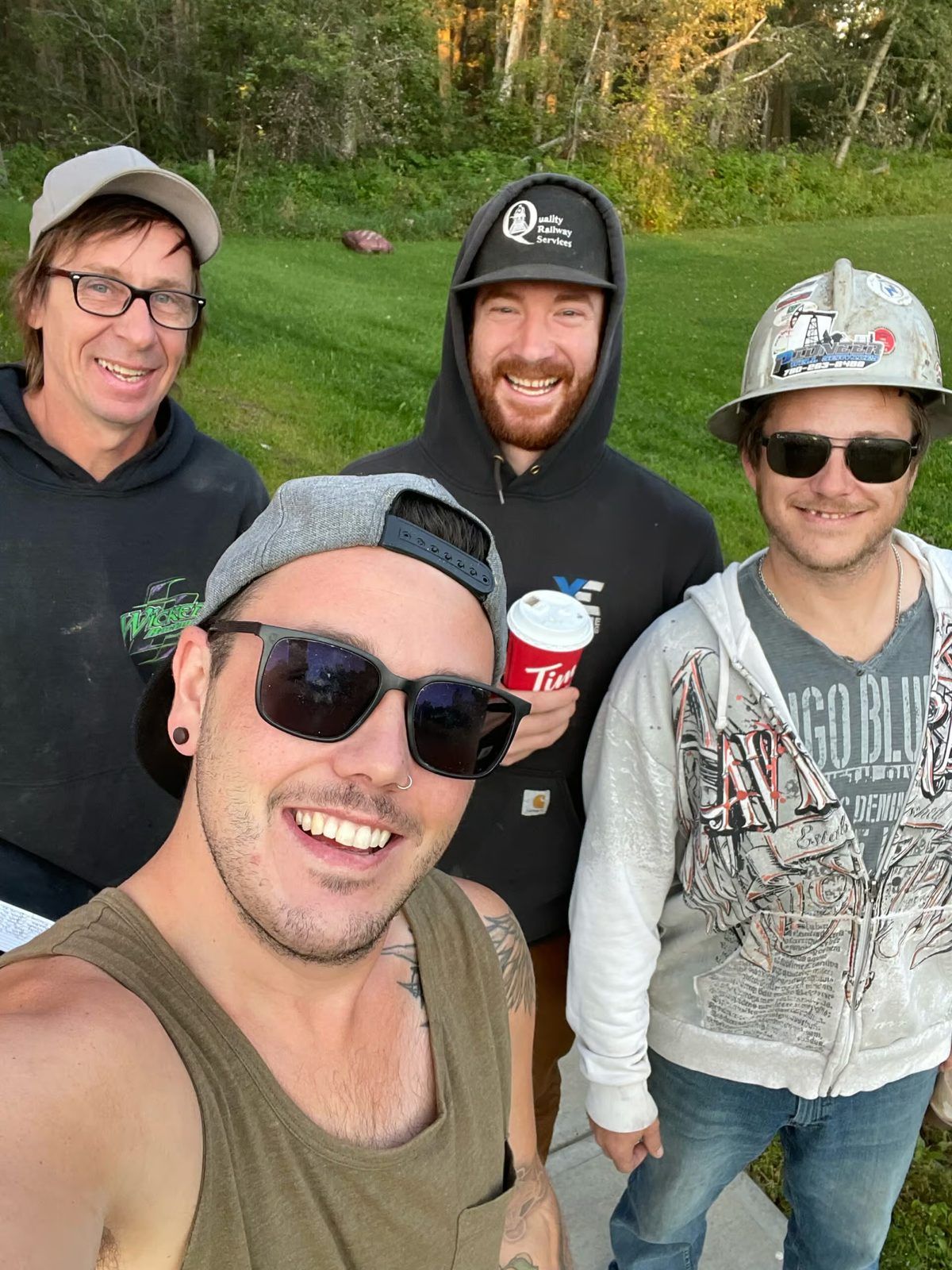 Four members of the West Imperial crew smiling for a selfie outdoors