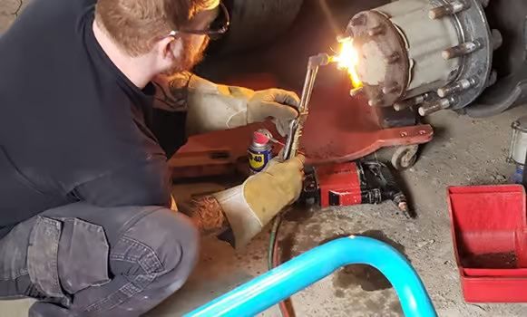 A West Imperial mechanic working on a truck in the shop