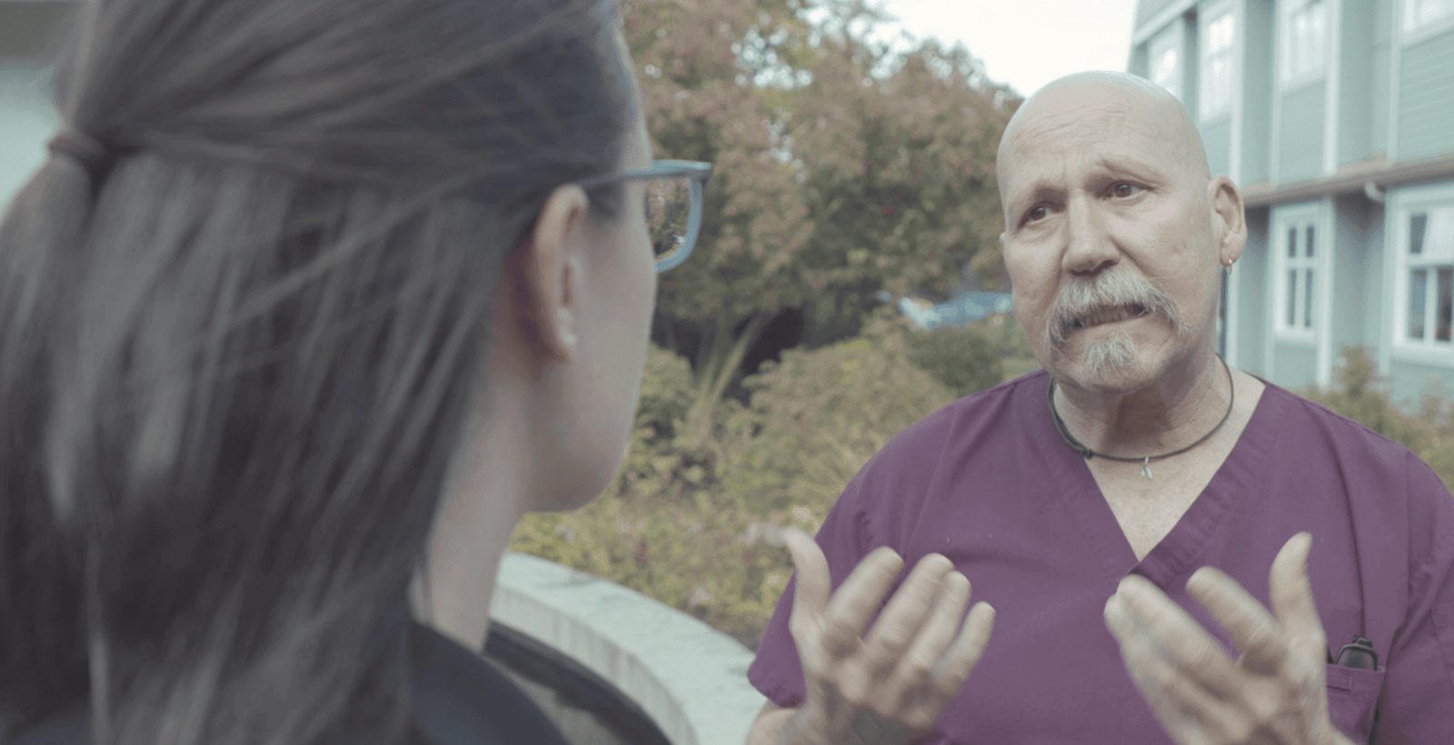 An interviewer listening as a man speaks on location