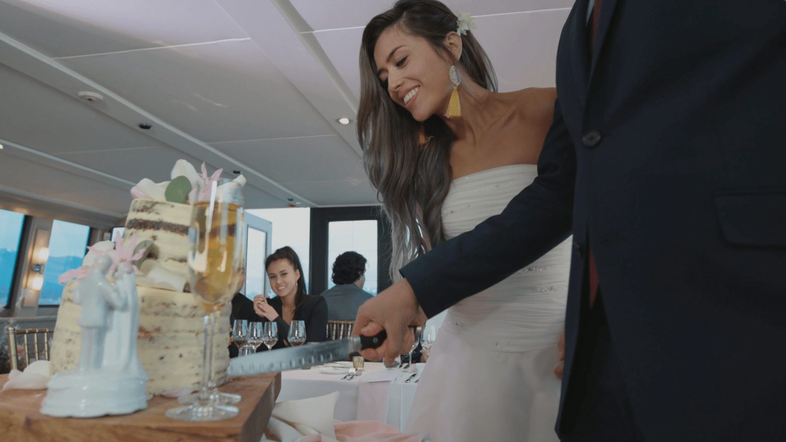 A couple cutting a cake in the salon of a yacht, from the Pacific Yacht Charters commercials